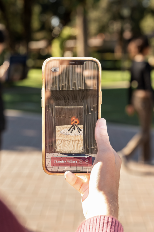An cell phone held up outside with Daly Science in the distant background.