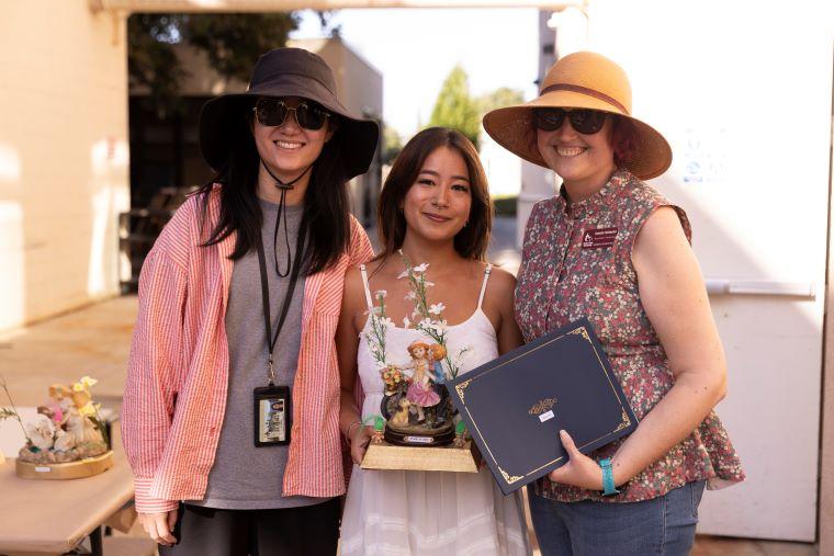 Two faculty with student accepting award