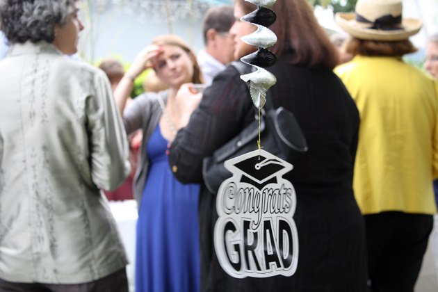 People gathered at a graduation brunch; a Grad 09 cap is in view.