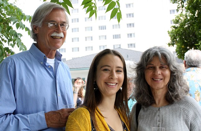 Three people smiling at Grad Brunch 2009. Trees and a building in the background.