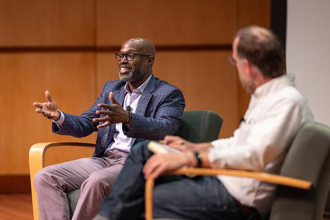 Kafui Dzirasa with Andrew Evans seated onstage at at Q&A 