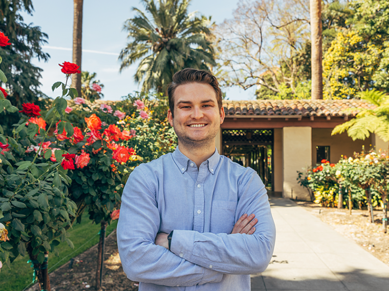 Henry Furguson standing next to rose bushes.