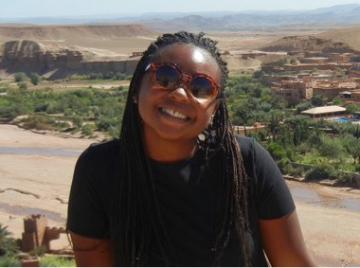 A person smiling with a landscape background in Deja story.