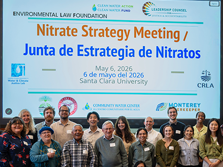A group of attendees in front of projection of Nitrate Strategy Meeting presentation title