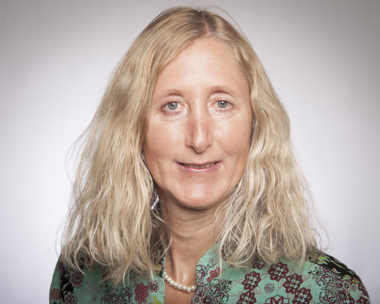 A person with long hair smiling at the camera.