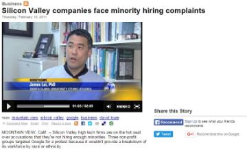  
Man speaking in a news interview about Lai minority hiring complaints, text on screen with subtitles.