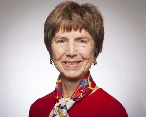 A person wearing a red outfit and a colorful scarf, named Gudrun.