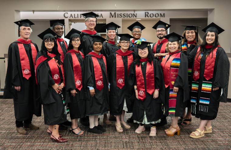 2026 graduates stand together looking at camera