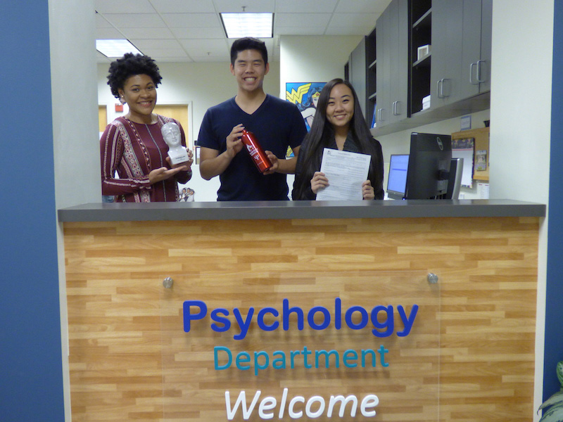 Three people behind front desk with Washington Animal Clinic sign.