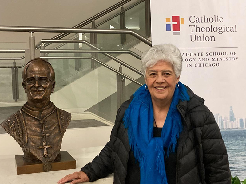 Ana Maria Pineda stands next to a statue of Pope Leo at the Catholic Theological Union in Chicago.