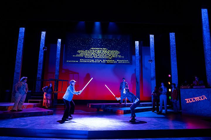 Scene from Shakespeares Twelfth Night set in a 1970s nightclub. 2 actors duel with lightsabers
