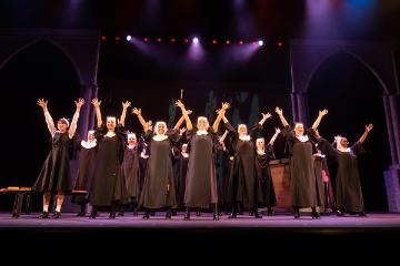 Sister Act nuns chorus group singing with arms raised to Heaven