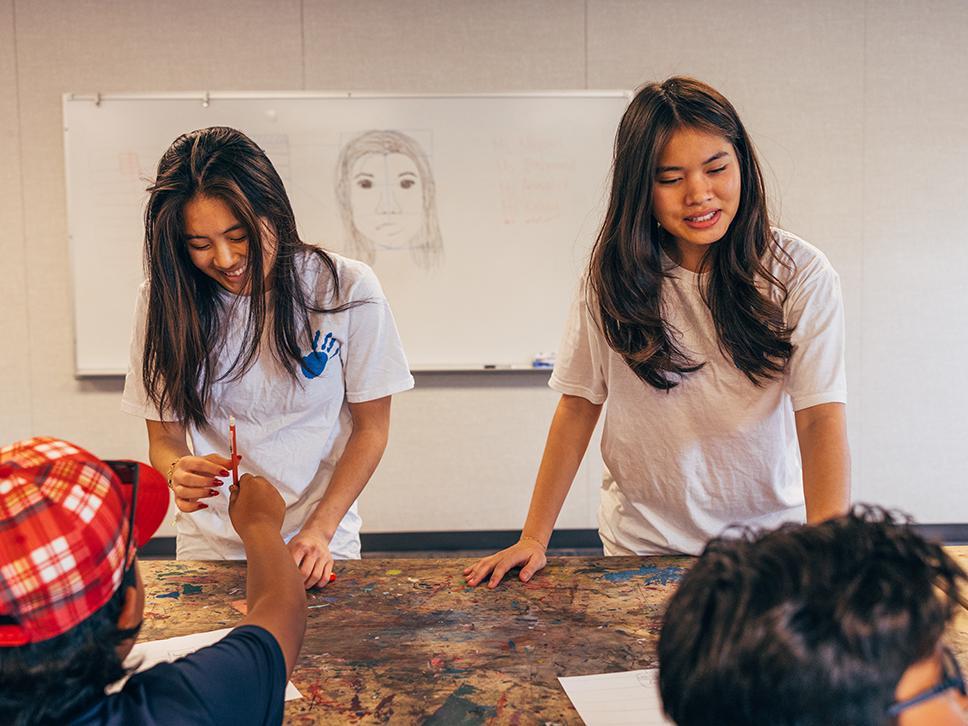 2 college seniors teaching a classroom of high schoolers