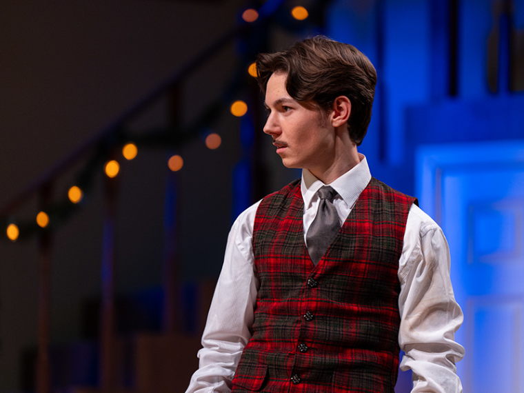 Christian Barnard in vest and tie on stage for the production of The Games Afoot