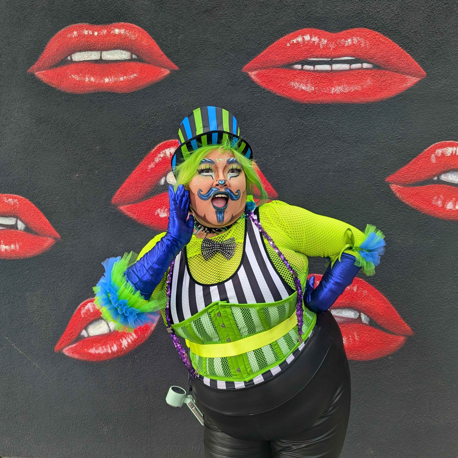 Drag 4 Justice Co-Producer Abbi Kiss posing in front of a wall.