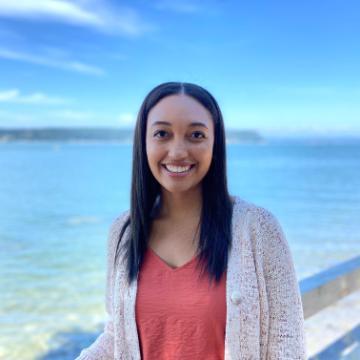 Woman smiling with an ocean background, titled Morayo Kamson.