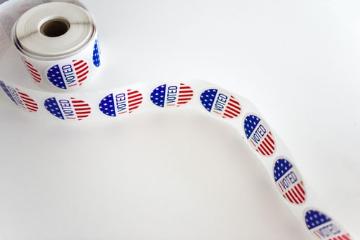 Roll of red white and blue pattern stickers with printed with I Voted slogan 