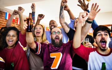 Friends cheering sport at bar together by rawpixel.com via Adobe Stock.