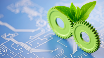 A computer logicboard with green cogs and leaves growing from it. 
