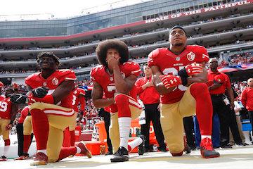 San Francisco 49ers outside linebacker Eli Harold, left, quarterback Colin Kaepernick, center, and safety Eric Reid kneel during the national anthem before the teams NFL football game against the Dallas Cowboys in Santa Clara, Calif. Kaepernick accepted Sports Illustrateds Muhammad Ali Legacy Award from Beyonce on Tuesday night, Dec. 5, 2017, and promised that with or without the NFLs platform