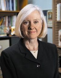 A person standing in an office, titled Cahill Headshot. image link to story