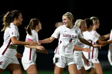 A soccer team celebrating a goal on the field.