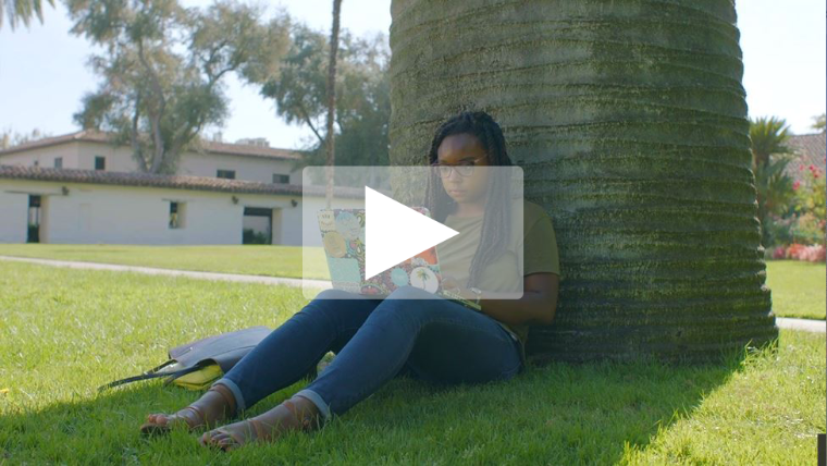 Thumbnail of a person sitting by a tree with a play button overlay.