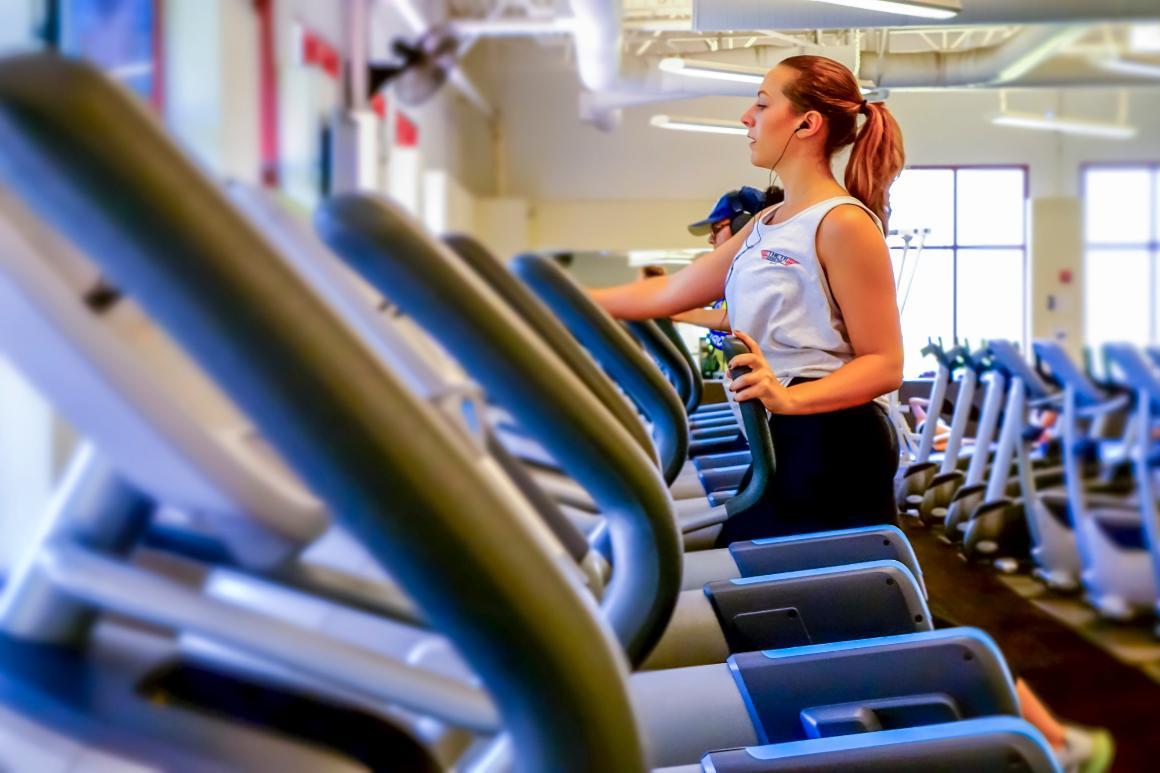 A person using a treadmill in a fitness center.