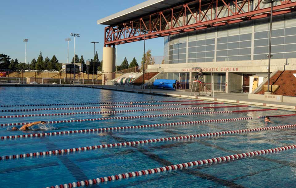 Outdoor swimming pool at an aquatic center with lanes and starting blocks.