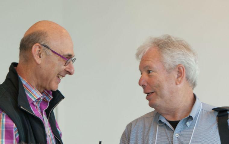 Hersh Shefrin and Richard Thaler greeting each other at a conference