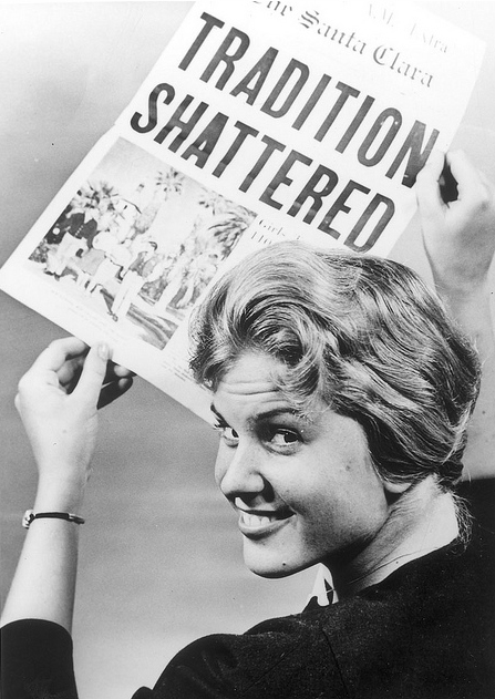 Woman holding newspaper with the headline Tradition Shattered