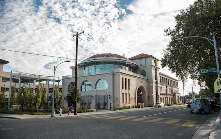 Street view of Dowd building with cloudy sky and trees.