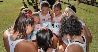King, center right, huddles with teammates.