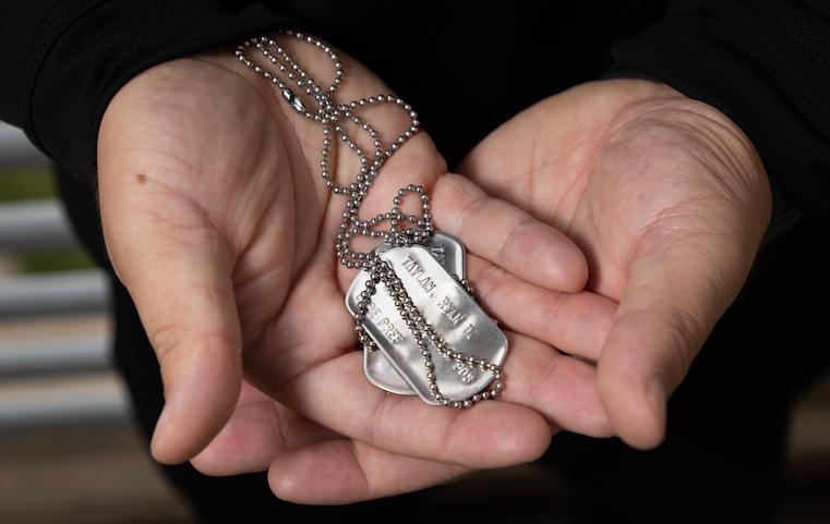 Ryan Taylan 22 holds a set of his U.S. Navy dog tags.
