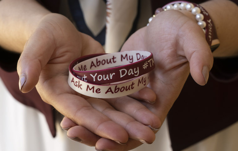 Hooria Jazaieri holds a pair of Tell Me, Ask Me wristbands.