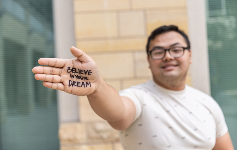 St. Thomas student with writing on hand that says Believe In Your Dream
