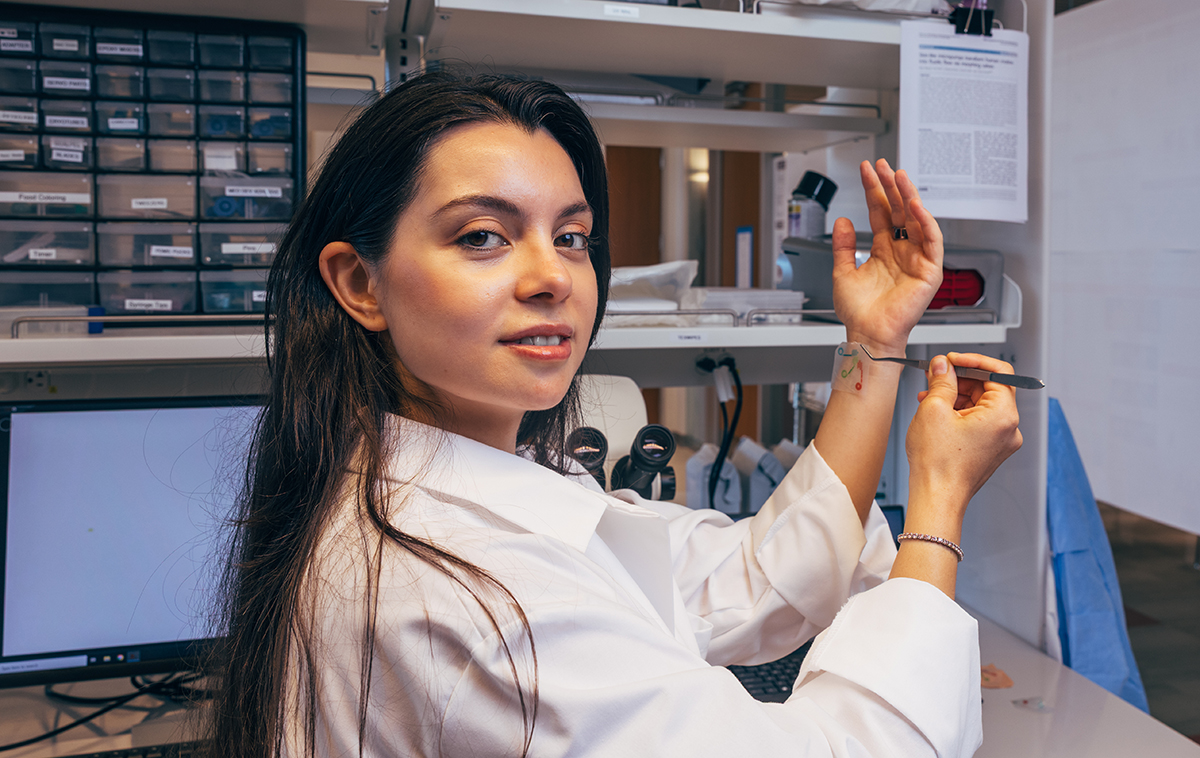 Rana Altay places microfluidic patch on wrist
