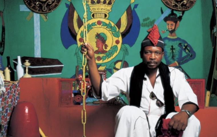 Photograph of vodou priest Volny Derosier, seated in his vodou temple in La Petite Rivière de lArtibonite, Haiti. Photo courtesy of Haiti ©Phyllis Galembo.