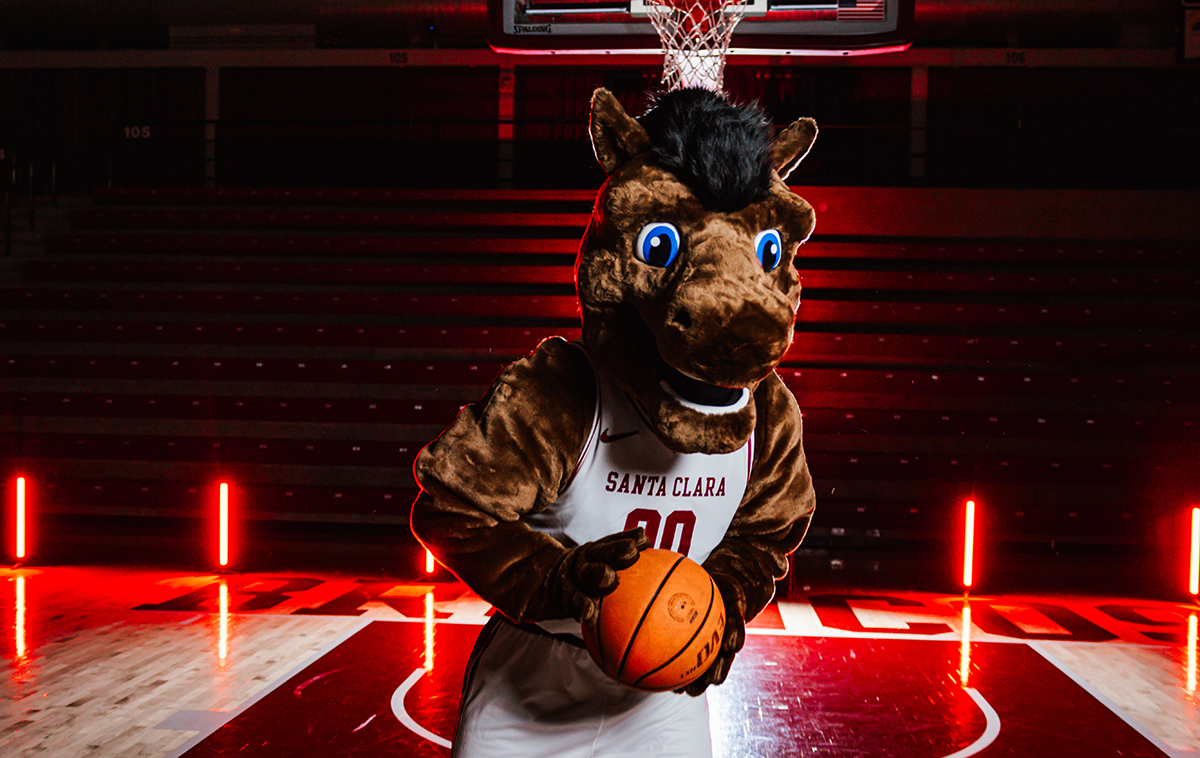 Bucky the Bronco holds a basketball in front of a basketball hoop with dramatic lighting emphasizing his new costume unveiling.