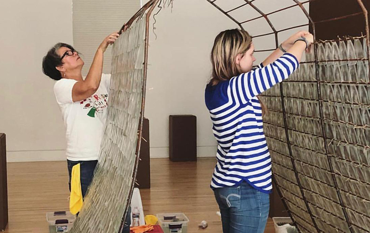 Athena Snyder 18 sets up an art exhibit at the Triton Museum in San Jose.