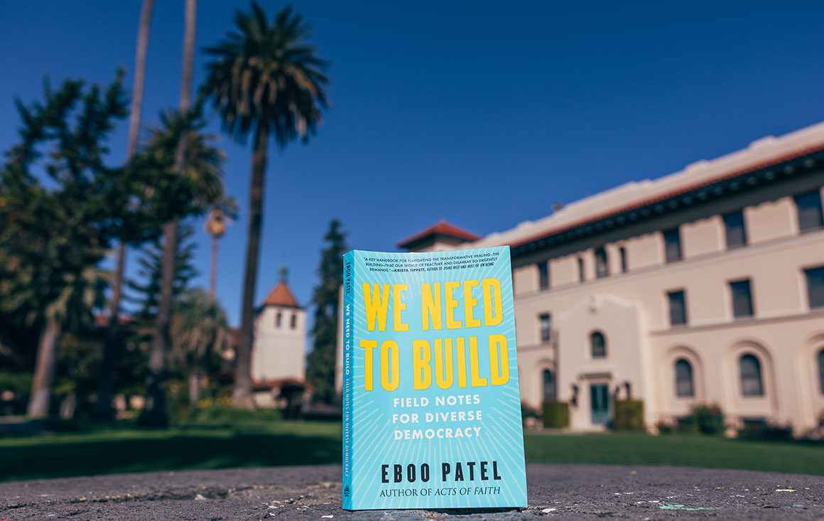 The book selected for this years Community Read sits in front of campus buildings and palm trees.