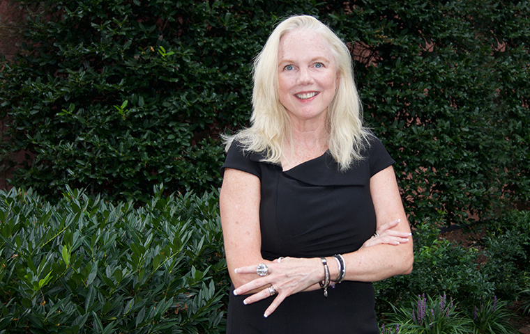 Brigit Helms, new ED of Miller Center, torso photo against dark background image link to story