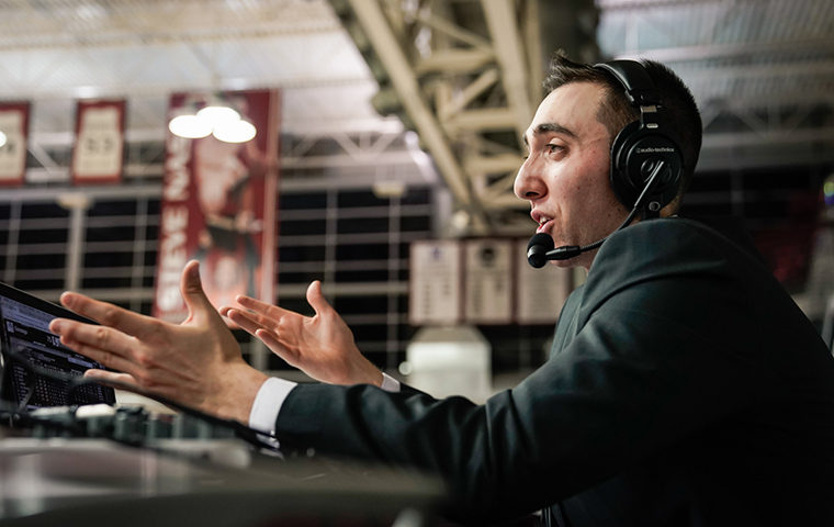 Jack Benjamin announces basketball game from scorers table