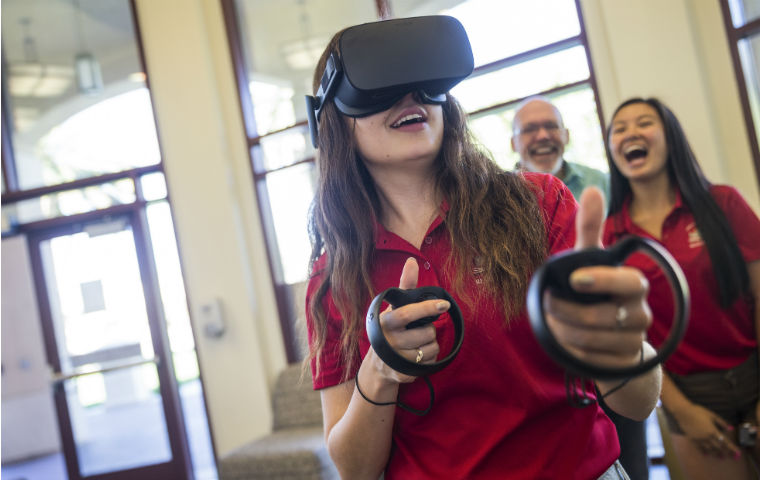Student using VR glasses with observers behind