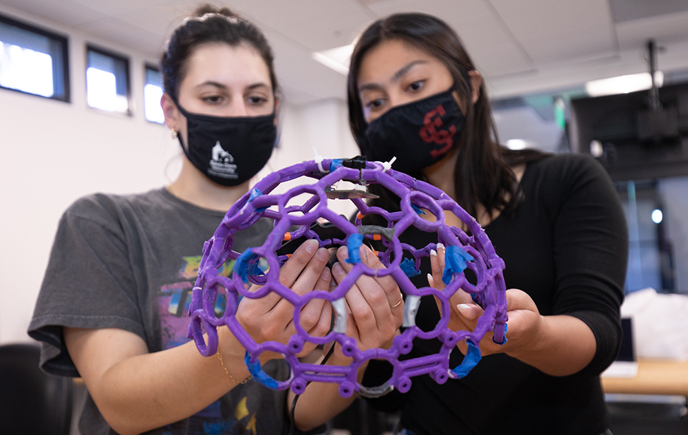ngineering students Louise Mantilla 22, left, and Michelle Wong 22, are part of a team designing a prototype that stimulates the brain with near infrared light. Photos by Jim Gensheimer.