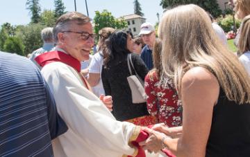 President Kevin OBrien shaking the hand of a staff member after the Feast of St. Ignatius