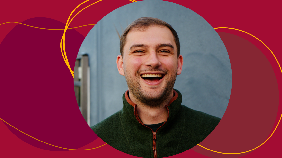 A man smiles on top of a red background with abstract shapes.