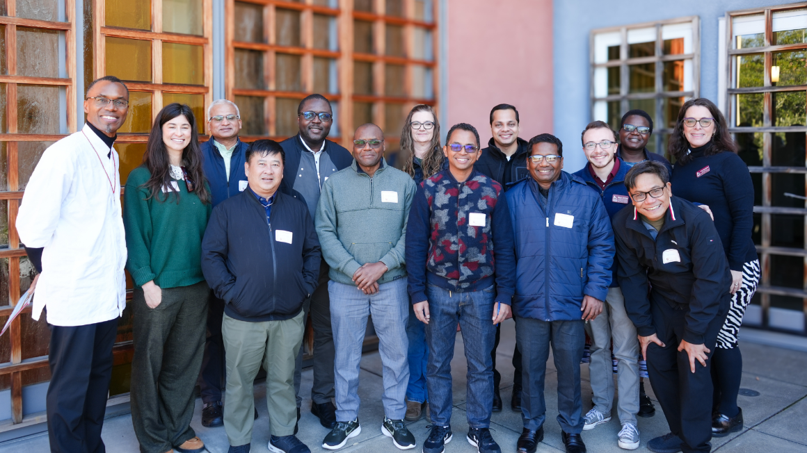 A diverse group of people smiling outdoors
