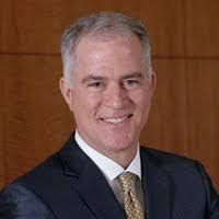 A man in a suit and tie smiling.