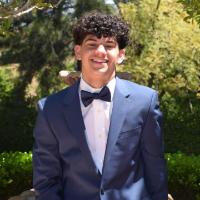 Troy Damu, SCU Accounting Association officer.  Smile, curly hair, tuxedo.